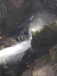 Agua cayendo con fuerza entre rocas en un cañón