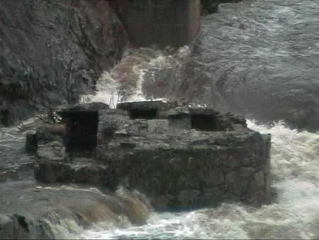 Agua espumosa alrededor de una estructura de piedra