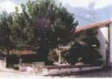Jardín con un árbol y un porche, en la casa rural El Hinojo