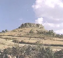 Cerro rocoso entre campos de labor