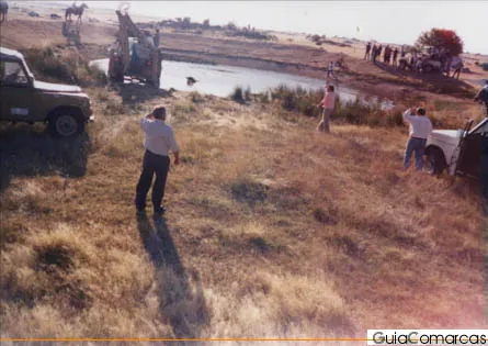Escena campestre con una persona y un vehículo, en una foto antigua