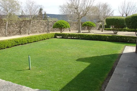 Jardín con césped y un muro