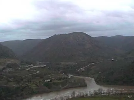 Paisaje de montañas bajo un cielo nublado con el río