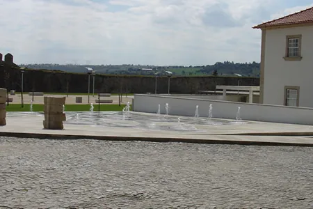 Plaza con un edificio y una muralla
